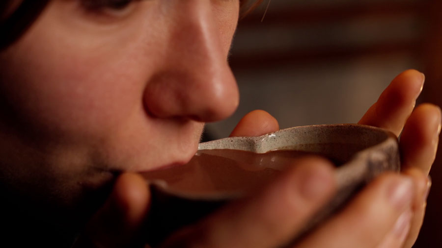 Человек делает глоток тёплого какао